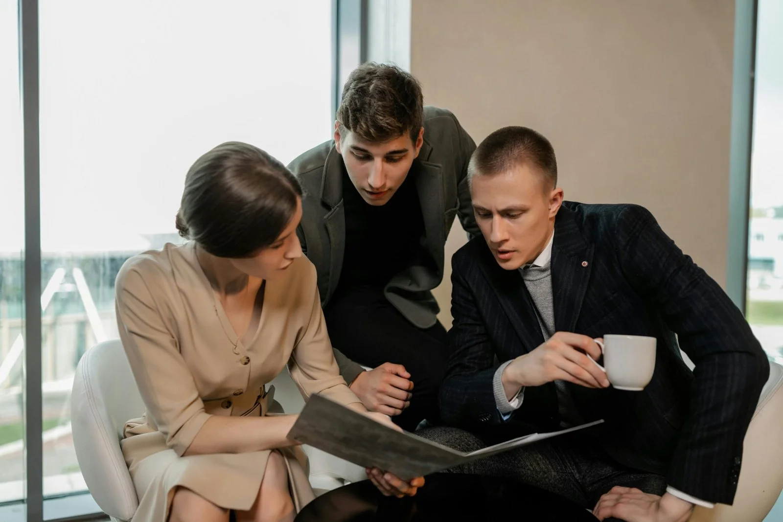 Three business professionals reviewing documents together for India to USA market entry planning